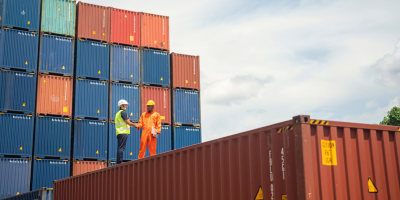 Two people on top of container