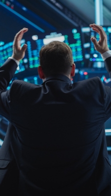 Image of people looking at the stock market on  large screens