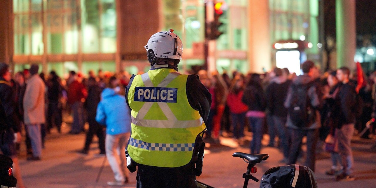 Image of police standing in front of a crowd 