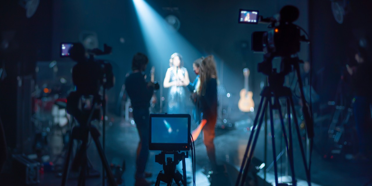 An image capturing the perspective from behind the camera as it records a singer or entertainer.
