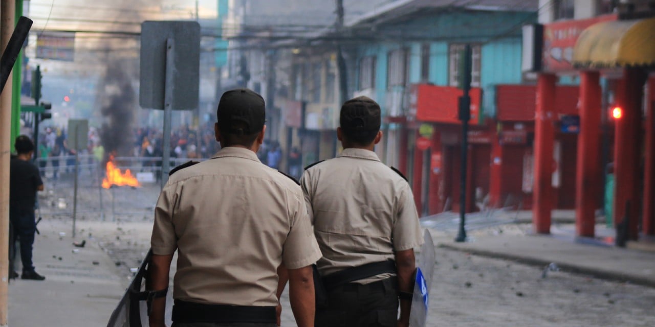 Photo of officers walking towards a disruption with firein a city
