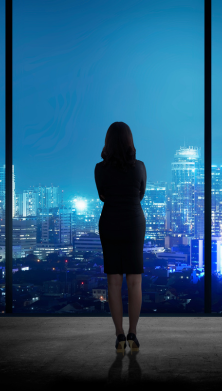 Photo of a woman standing looking at the view of a city 
