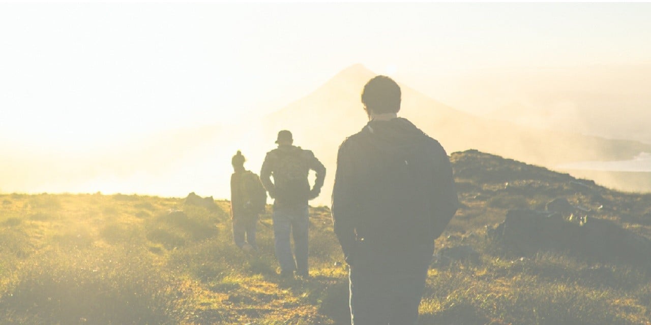 Photo of three people in an open field