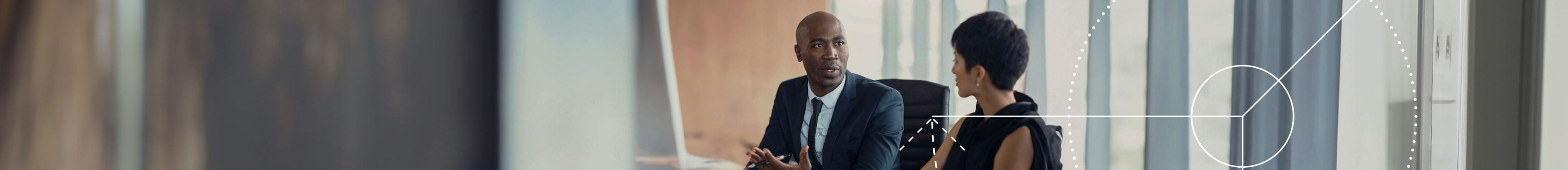 Business partners (a woman and a man) having a lively conversation at a conference table.