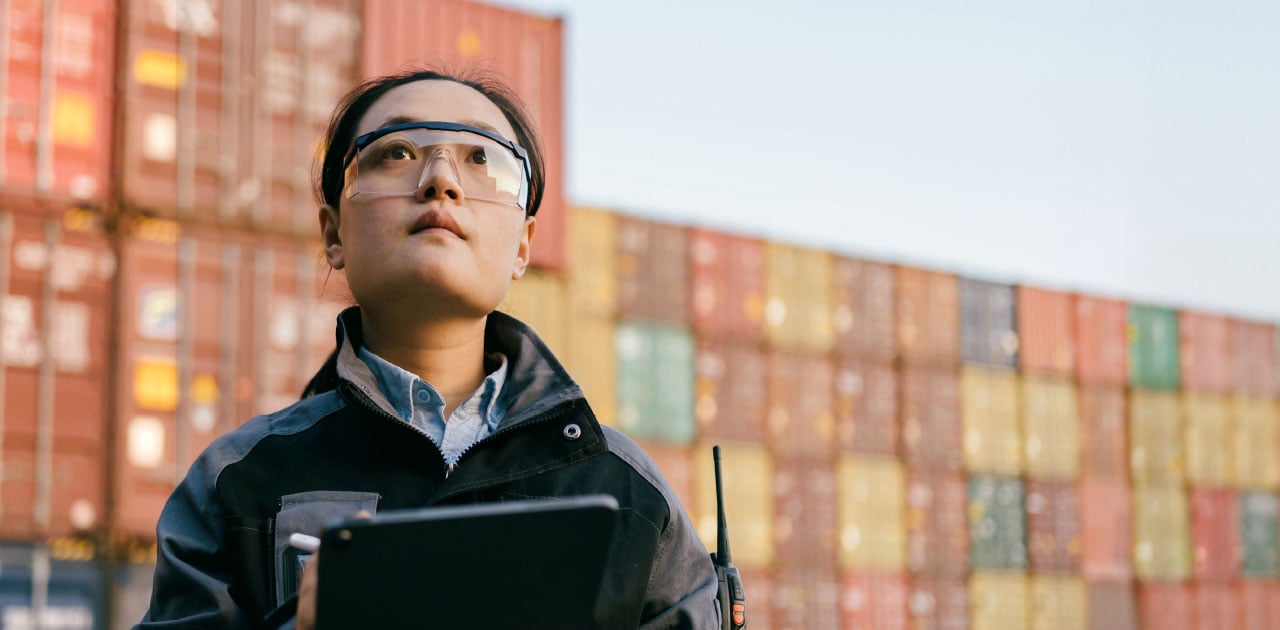 Female cargo specialist, many cargo containers in the background