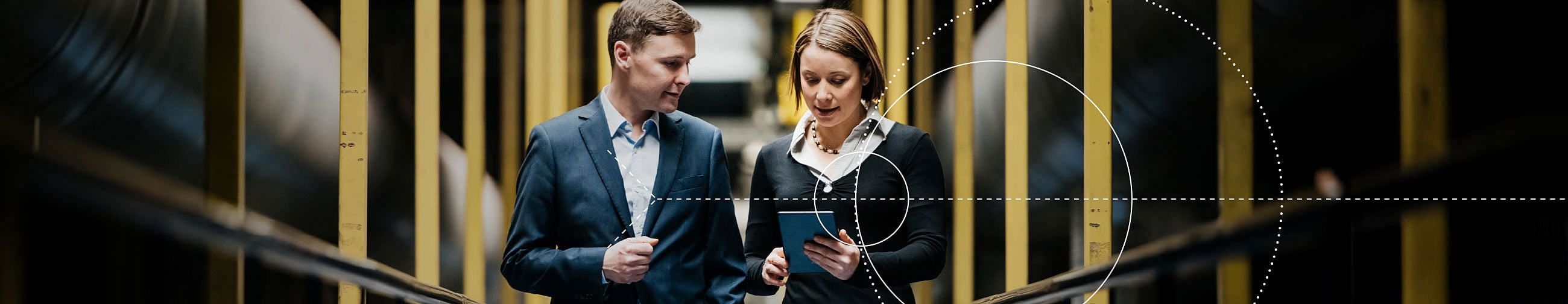  Business partners (woman and man) walking down a hallway discussing
